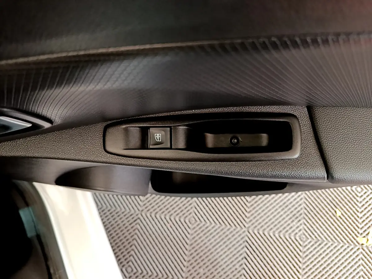 Détail de la commande de lève-vitre côté conducteur dans l'habitacle d'une Renault Clio Business blanc 2019.