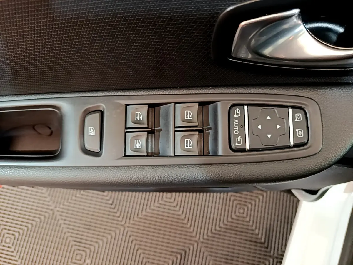 Vue rapprochée des commandes de lève-vitres et rétroviseurs sur la porte côté gauche d'une Renault Clio blanche 2019.