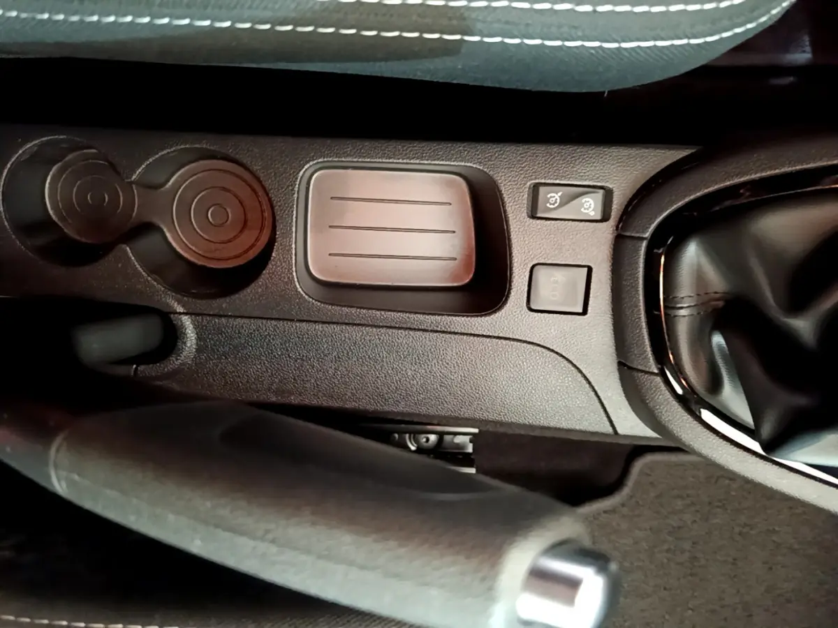 Gros plan sur la console centrale noire de la Renault Clio Business TCe 90 2019, avec frein à main et commandes proches du levier de vitesse.
