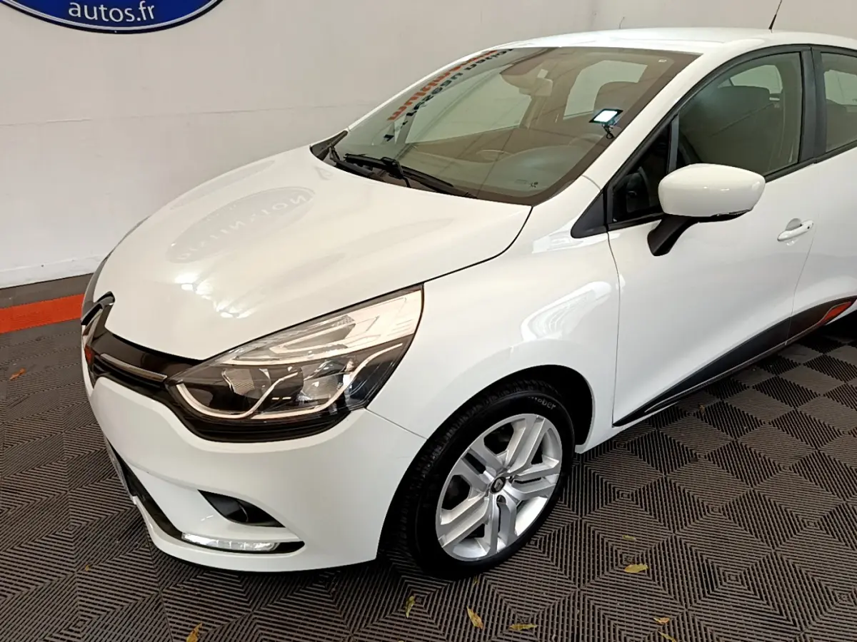 Renault Clio Business TCe 90 blanc vue 3/4 avant droit, avec phares LED et jantes alliage visibles.