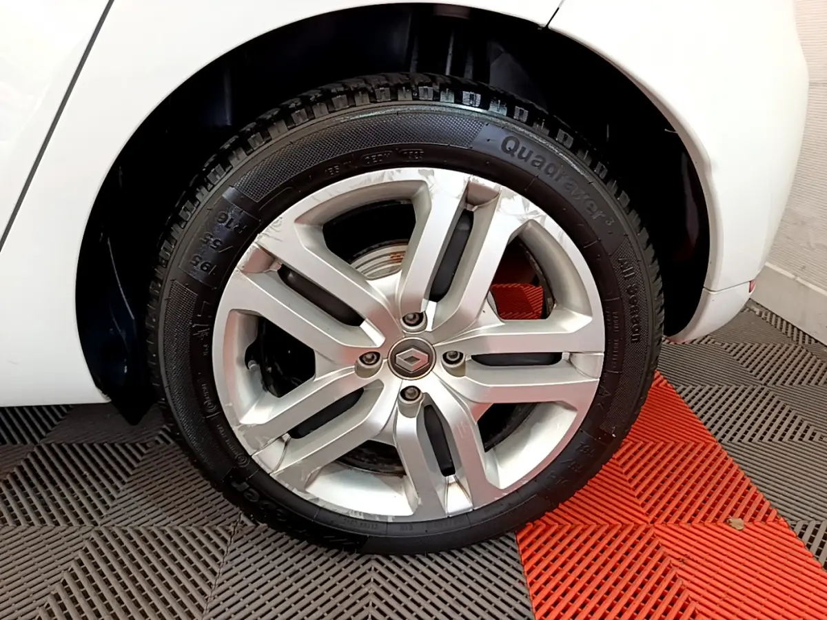 Gros plan sur la roue avant droite blanche d'une Renault Clio Business TCe 90 avec jante alliage argentée.