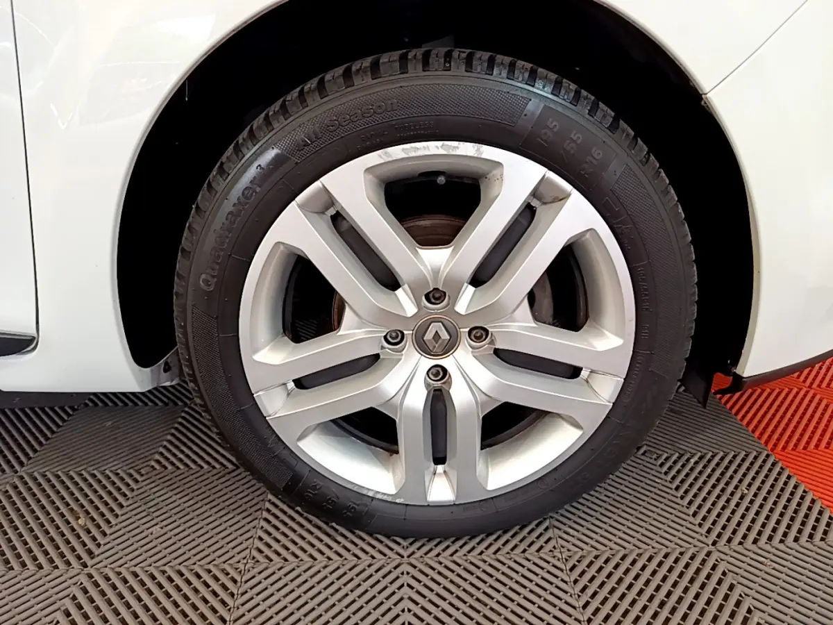 Gros plan sur la roue avant droite blanche d'une Renault Clio Business TCe 90 avec jante alliage argentée.