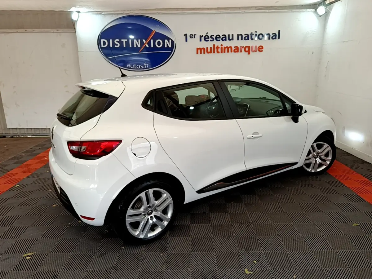 Renault Clio Business TCe 90 blanc vue 3/4 arrière droit en intérieur avec jantes alliage et feux arrière LED.
