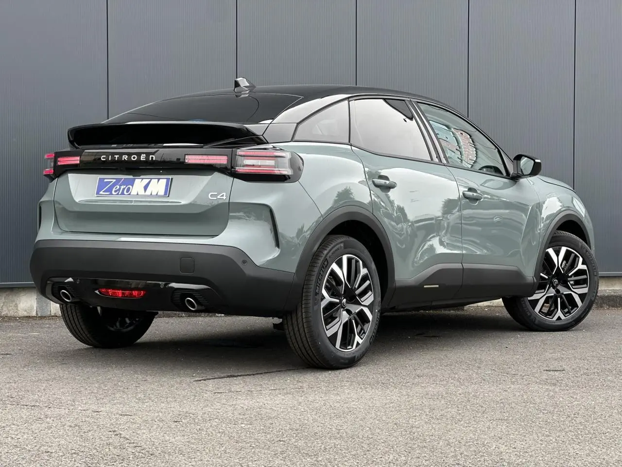 Vue 3/4 arrière droite d'une Citroën C4 Manhattan Green avec toit noir et feux arrière LED distinctifs.