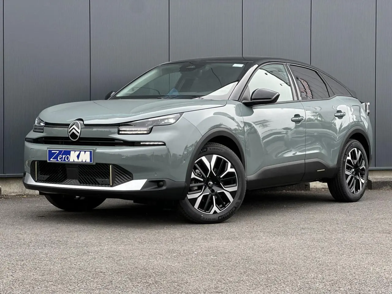 Citroën C4 2025 Manhattan Green vue 3/4 avant avec toit noir et jantes alliage 18 pouces noires et argentées.