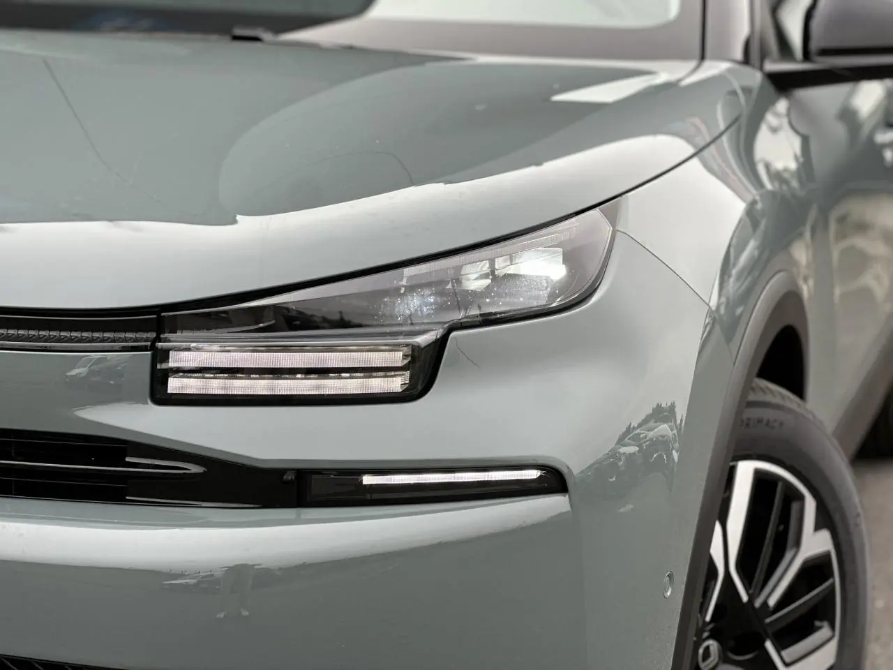 Gros plan sur l'avant droit de la Citroën C4 Manhattan Green avec ses phares LED et jante alliage noire et argent.