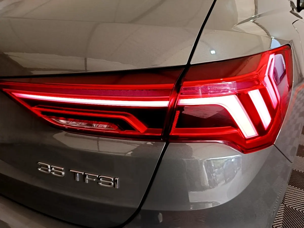 Gros plan sur le feu arrière droit rouge et la carrosserie gris foncé de l'Audi Q3 35 TFSI 2021.