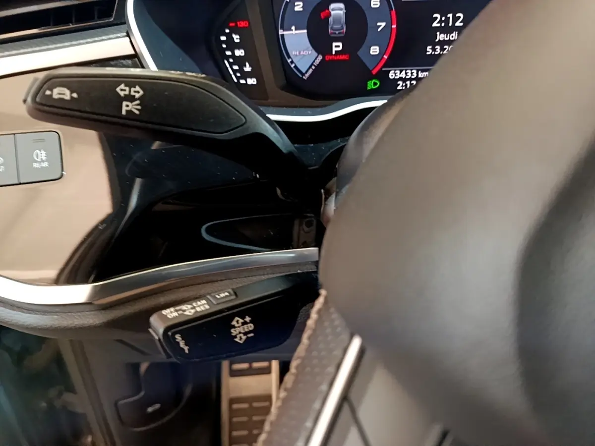 Gros plan sur le volant cuir et les commandes multifonctions du tableau de bord de l'Audi Q3 gris foncé 35 TFSI 2021.