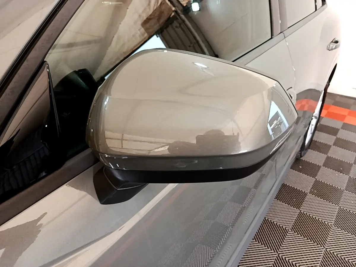 Rétroviseur côté conducteur gris foncé de l'Audi Q3 35 TFSI 150 MHEV S Line, vue rapprochée en intérieur.