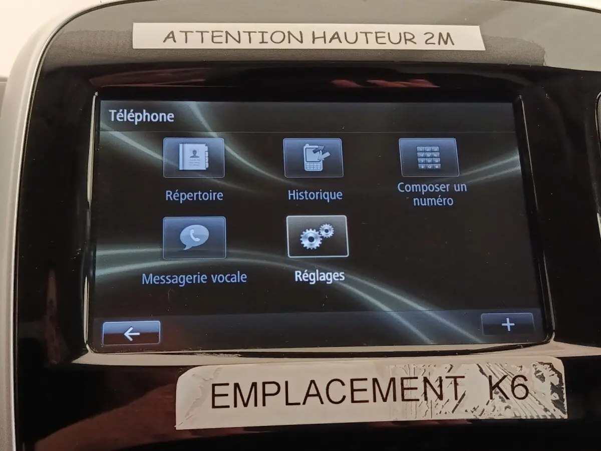 Écran tactile central du Renault Trafic Fourgon blanc, affichant le menu téléphone avec options de répertoire et réglages.