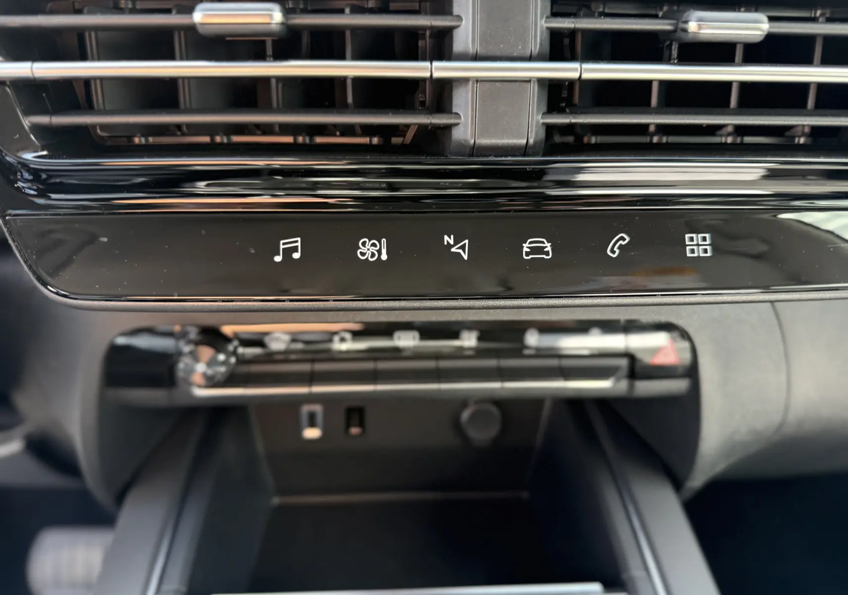Vue rapprochée de la console centrale du Citroën C5 Aircross Hybrid 2025, avec commandes tactiles et aérateurs noirs.