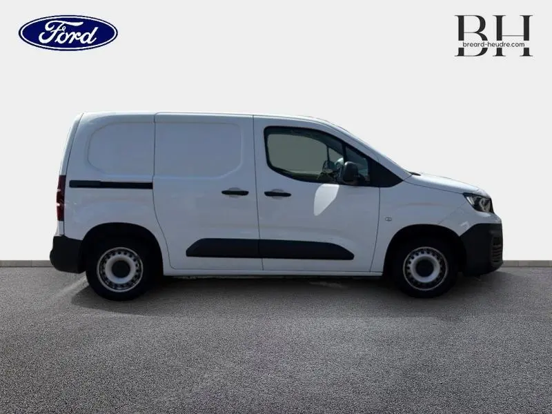 Vue latérale droite d'un Peugeot Partner blanc Icy 2019 avec portes arrière battantes et protections noires sur les portières.
