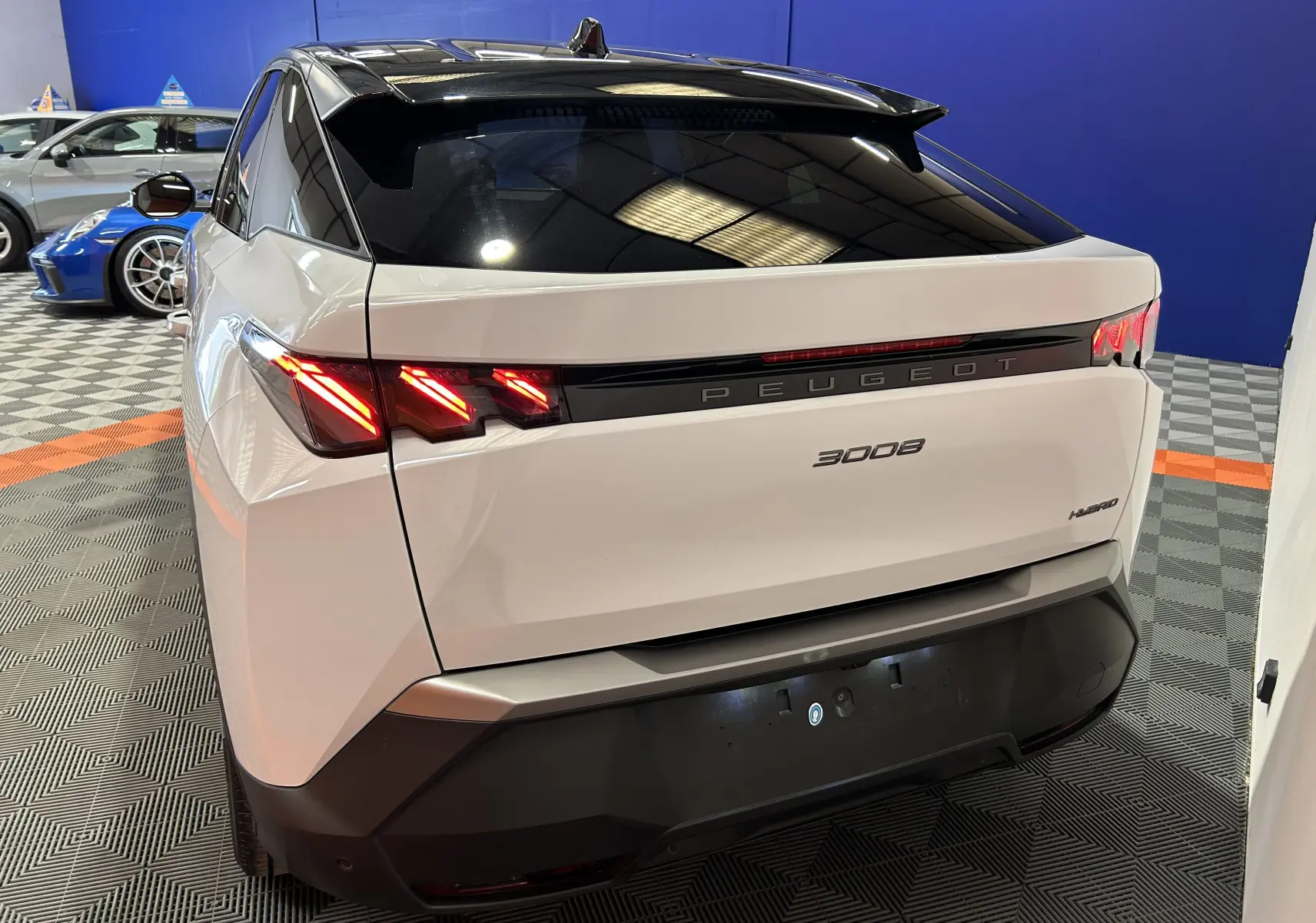 Vue 3/4 arrière droite du Peugeot 3008 blanc Okenite avec feux LED distinctifs et toit noir brillant.