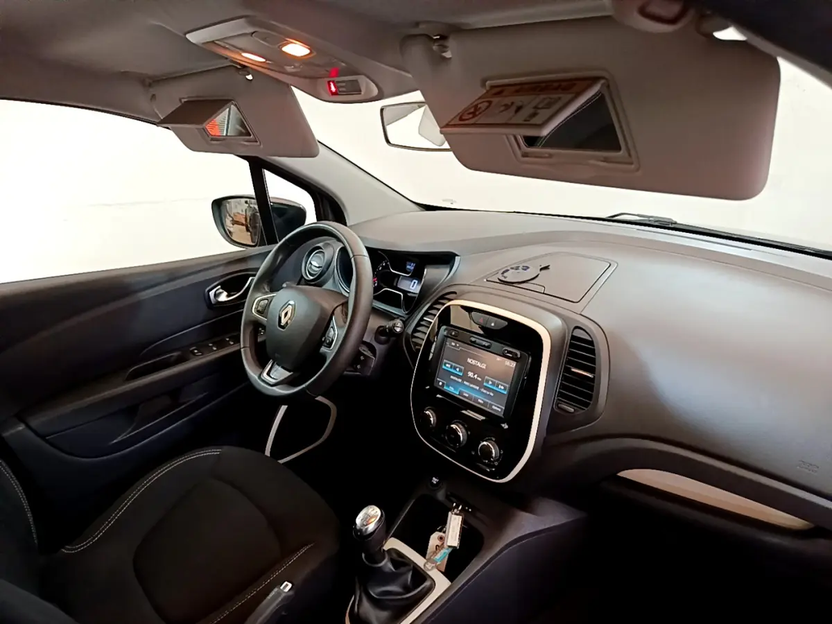 Intérieur noir du Renault Captur Business TCe 90 2018 vu côté conducteur, avec tableau de bord et écran tactile central.