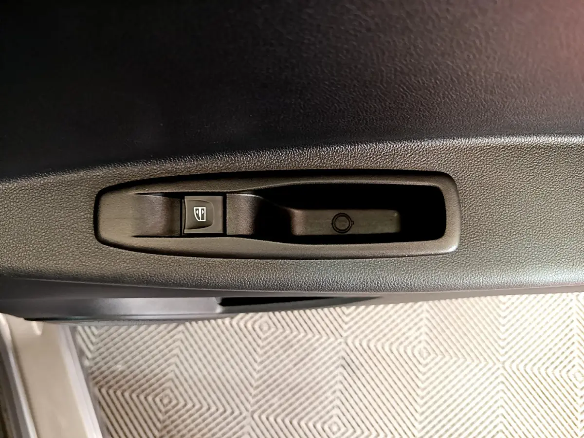 Bouton de commande de lève-vitre sur la porte intérieure côté conducteur d’un Renault Captur gris foncé 2018.