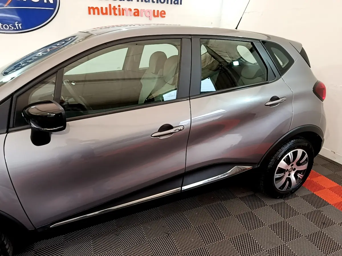 Profil côté gauche d'un Renault Captur gris foncé 2018 avec rétroviseurs noirs et jantes alliage visibles.