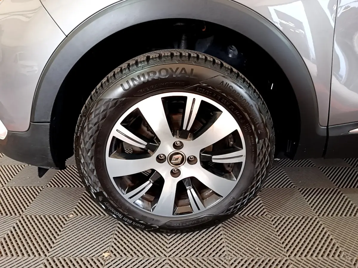 Gros plan sur la roue avant gauche du Renault Captur gris foncé, mettant en valeur la jante alliage et le pneu Uniroyal.