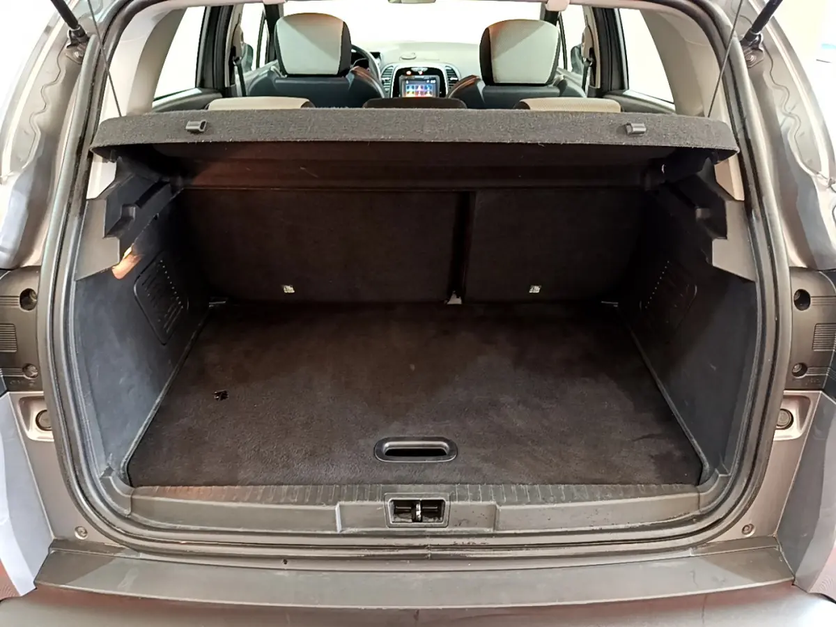 Coffre ouvert vu de l'arrière d'un Renault Captur gris foncé, montrant l'espace de chargement et les sièges arrière.