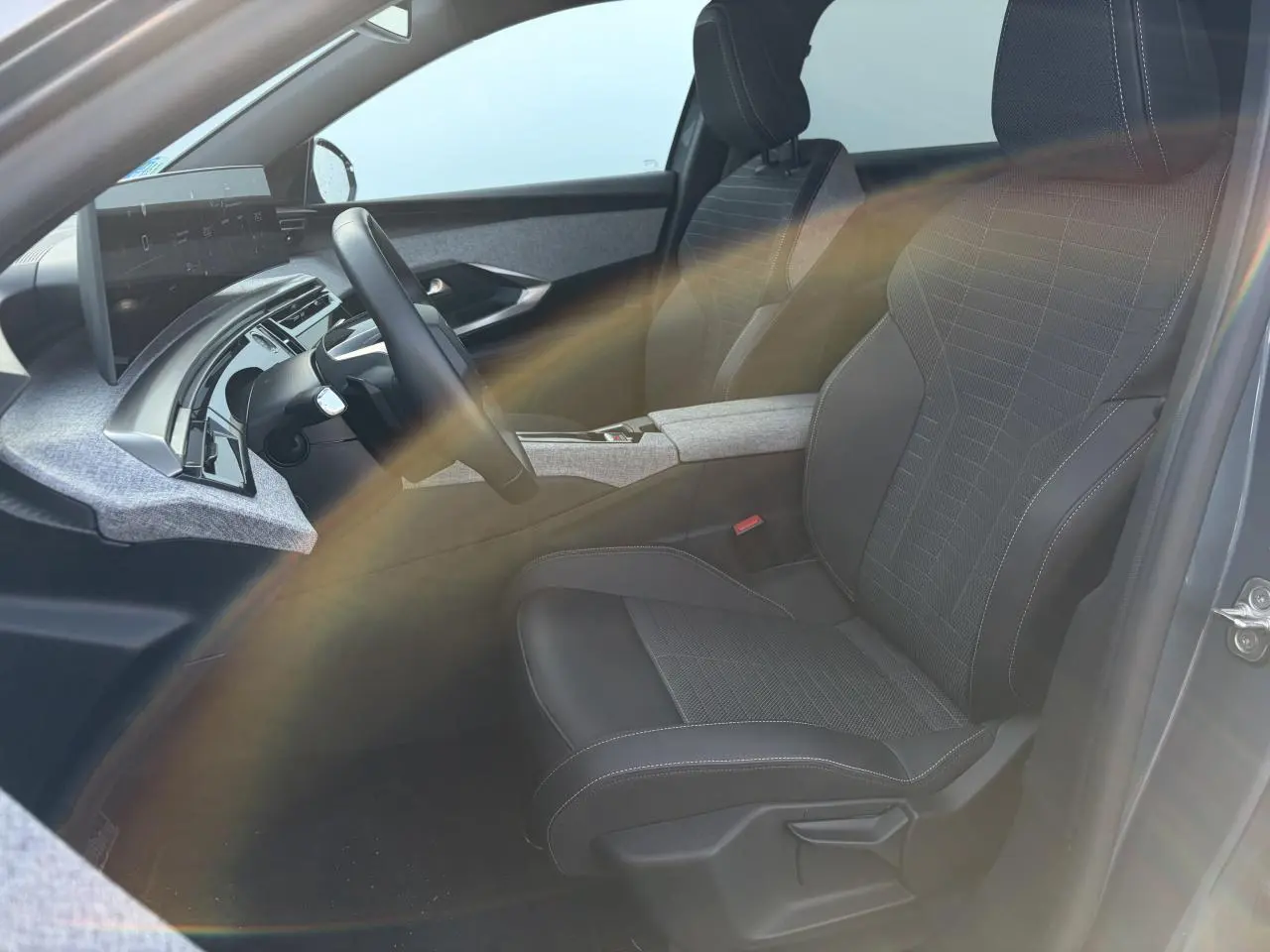 Vue intérieure côté conducteur du Peugeot 3008 bleu Ingaro, avec sellerie tissu Uziris et tableau de bord i-Cockpit panoramique.