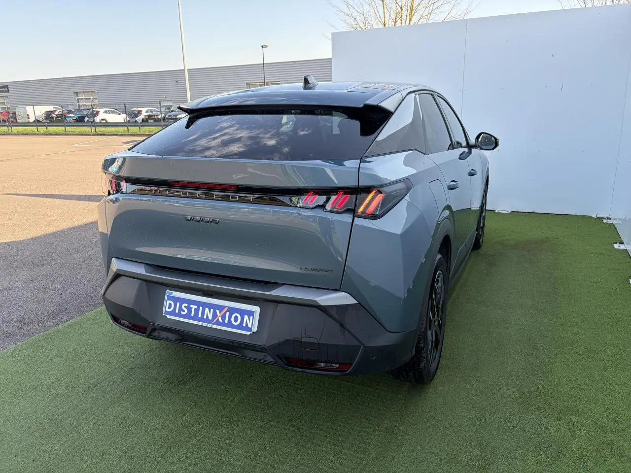 Vue 3/4 arrière droite d’un Peugeot 3008 bleu Ingaro avec feux arrière à LED en forme de griffes et toit noir brillant.