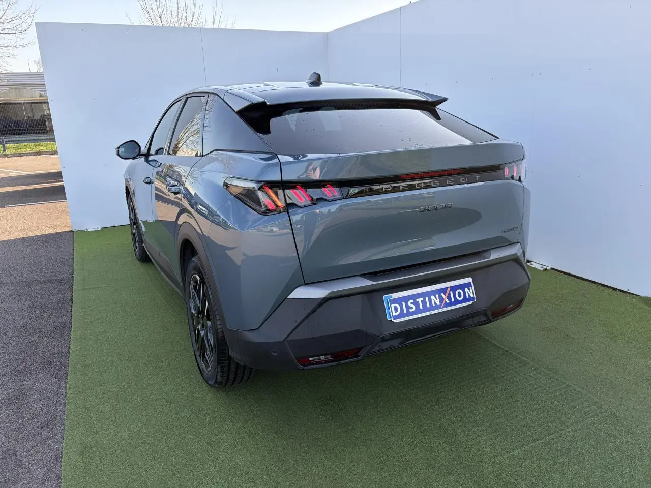 Vue 3/4 arrière droite du Peugeot 3008 bleu Ingaro avec feux arrière à LED en forme de griffes et jantes alliage noires.