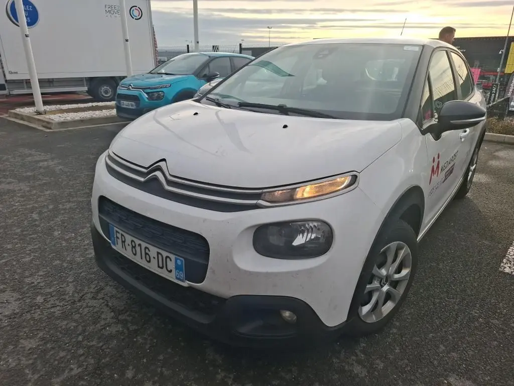 Vue 3/4 avant droit d'une Citroën C3 Société blanche de 2020 avec clignotant avant droit allumé et logo sur porte.