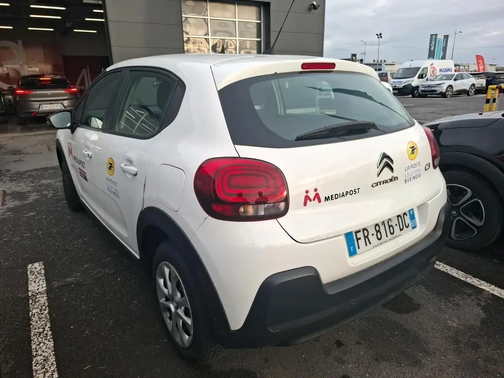 Vue 3/4 arrière droite d'une Citroën C3 Société blanche de 2020 avec logos Mediapost et La Poste sur le hayon.