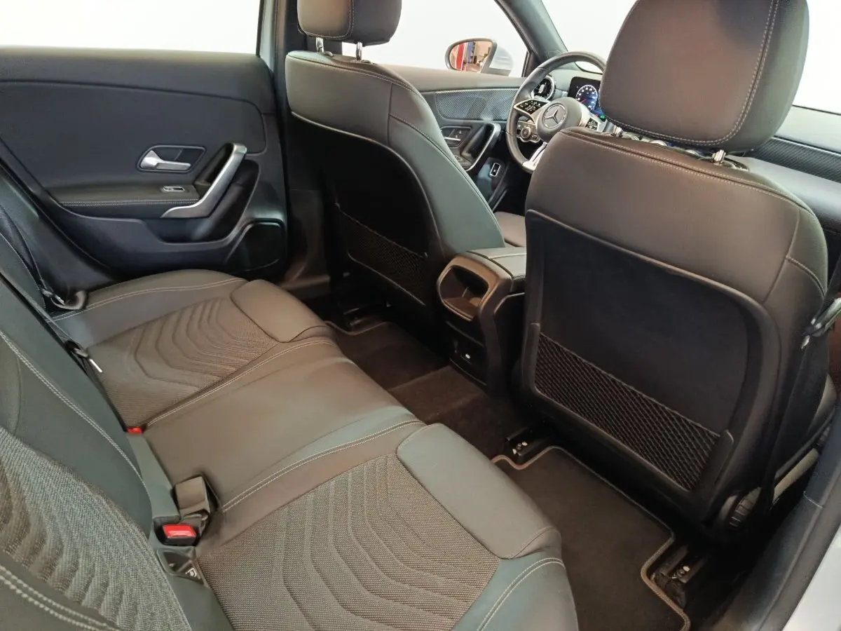 Intérieur arrière du Mercedes GLA 250 e Business Line 2023, sièges noirs en cuir et tissu, vue côté gauche vers l'avant.