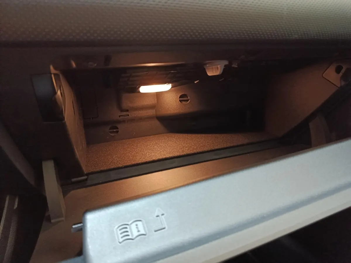 Intérieur du vide-poches côté passager éclairé de la Mercedes GLA 250 e Business Line 2023 gris foncé.