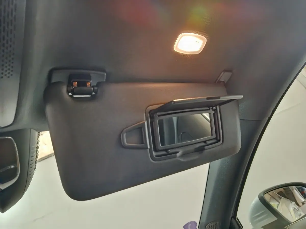 Détail intérieur du pare-soleil côté conducteur avec miroir éclairé d'une Mercedes GLA 250 e Business Line 2023.