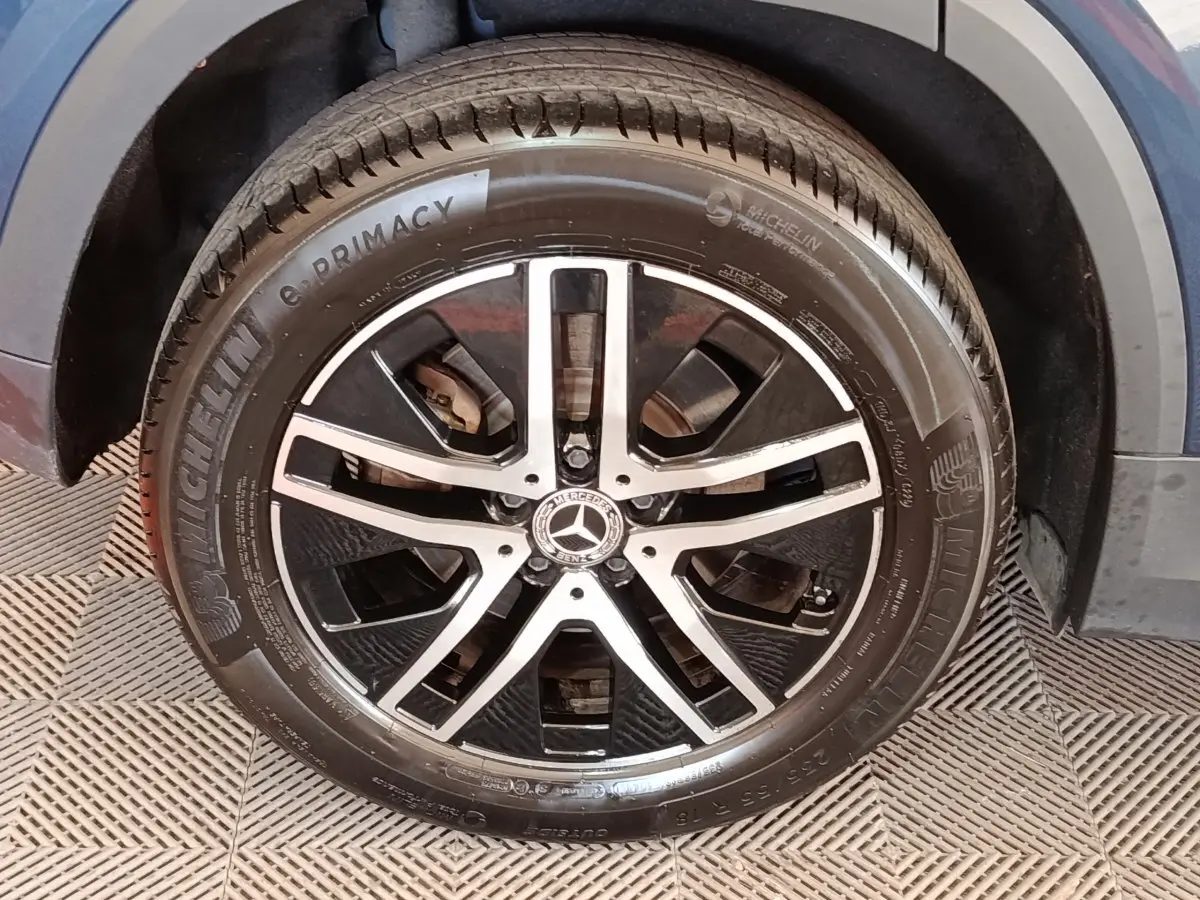 Gros plan sur la roue avant droite gris foncé du Mercedes GLA 250 e Business Line avec jante alliage noire et argentée.
