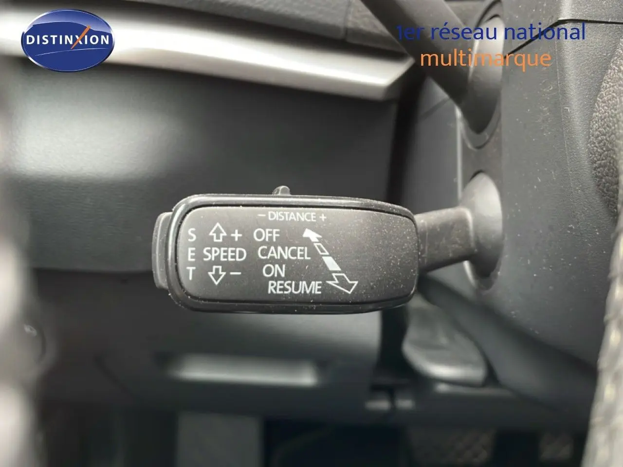 Gros plan sur la commande de régulateur de vitesse du Skoda Karoq 2025, intérieur noir, détails des fonctions visibles.