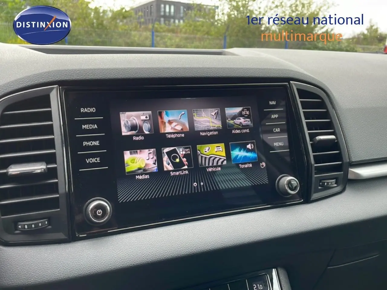 Écran tactile central du tableau de bord du Skoda Karoq blanc glacier, vue rapprochée de la console multimédia.