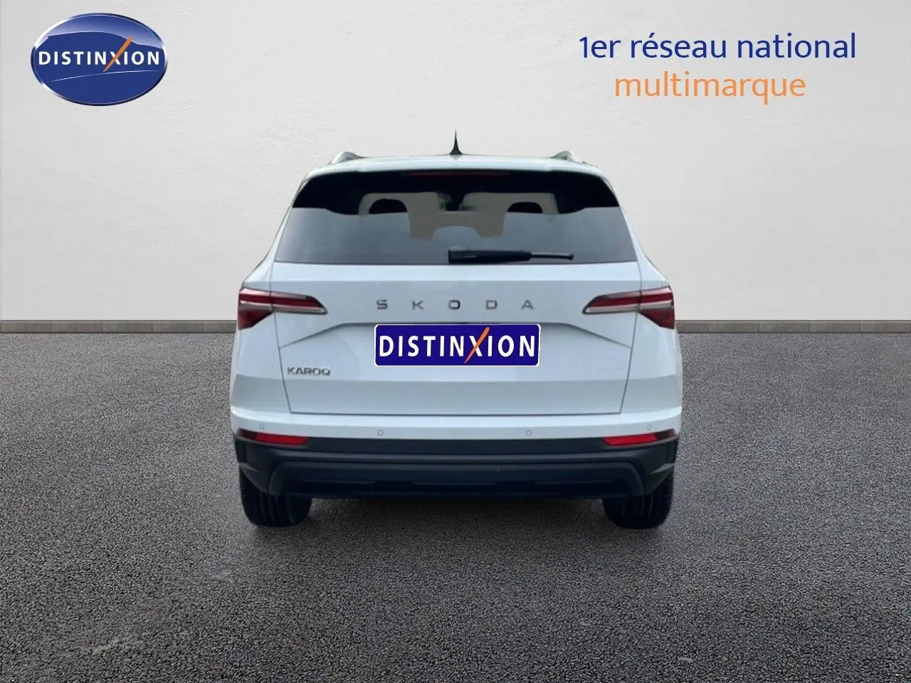 Vue arrière d'un Skoda Karoq blanc glacier 2025, avec feux arrière LED et logo SKODA bien visible.