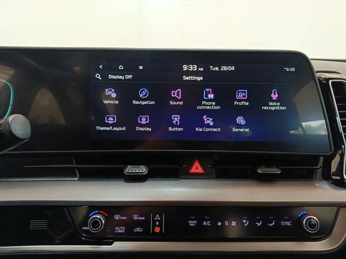 Vue rapprochée de l’écran tactile central et des commandes de climatisation du tableau de bord du Kia Sportage blanc 2022.
