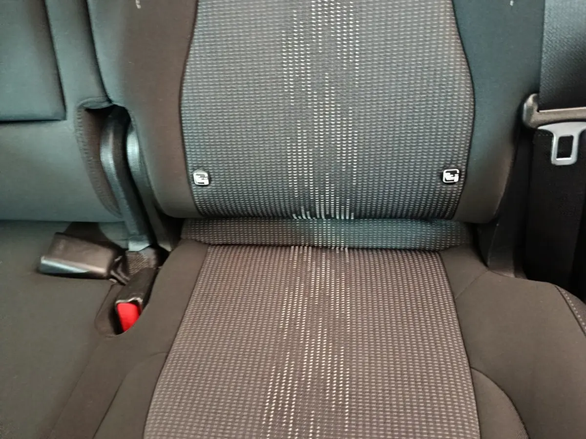 Gros plan sur la banquette arrière noire du Kia Sportage 2022, montrant les fixations Isofix et la ceinture de sécurité.