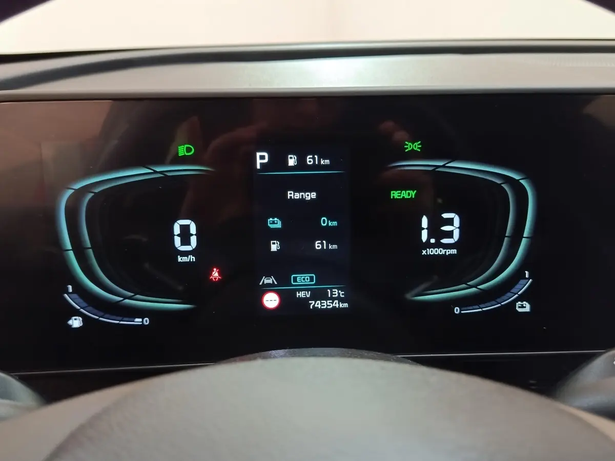 Affichage numérique du tableau de bord du Kia Sportage hybride rechargeable, indiquant vitesse, régime et autonomie.