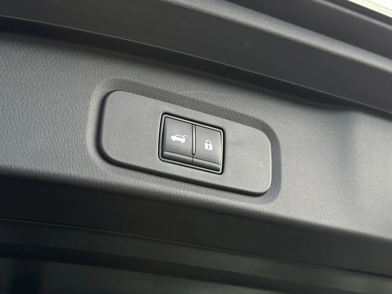 Boutons de commande du hayon électrique et verrouillage sur le hayon intérieur d'un Nissan Qashqai noir nacré 2025.