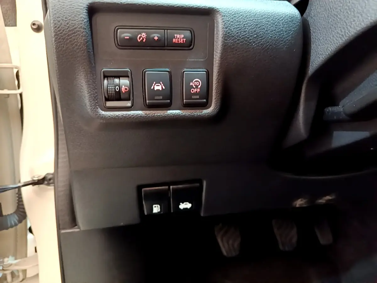 Vue rapprochée des commandes côté gauche du tableau de bord d'une Nissan Micra blanche 2022 IG-T 92 Acenta.