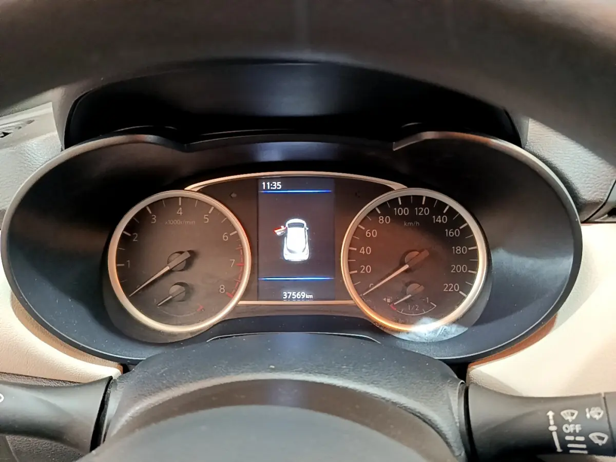 Vue rapprochée du tableau de bord de la Nissan Micra blanche 2022, affichant compte-tours, vitesse et écran central.