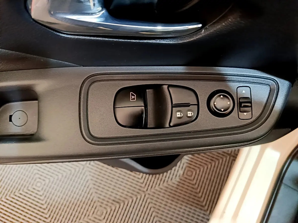 Gros plan sur les commandes de lève-vitres et rétroviseurs côté conducteur d'une Nissan Micra blanche 2022.