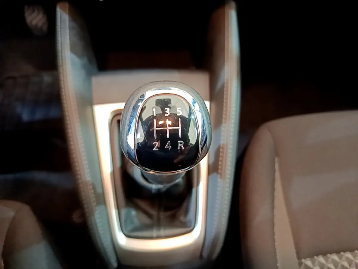 Le levier de vitesses manuel vu de dessus dans l'habitacle beige de la Nissan Micra IG-T 92 Acenta 2022.