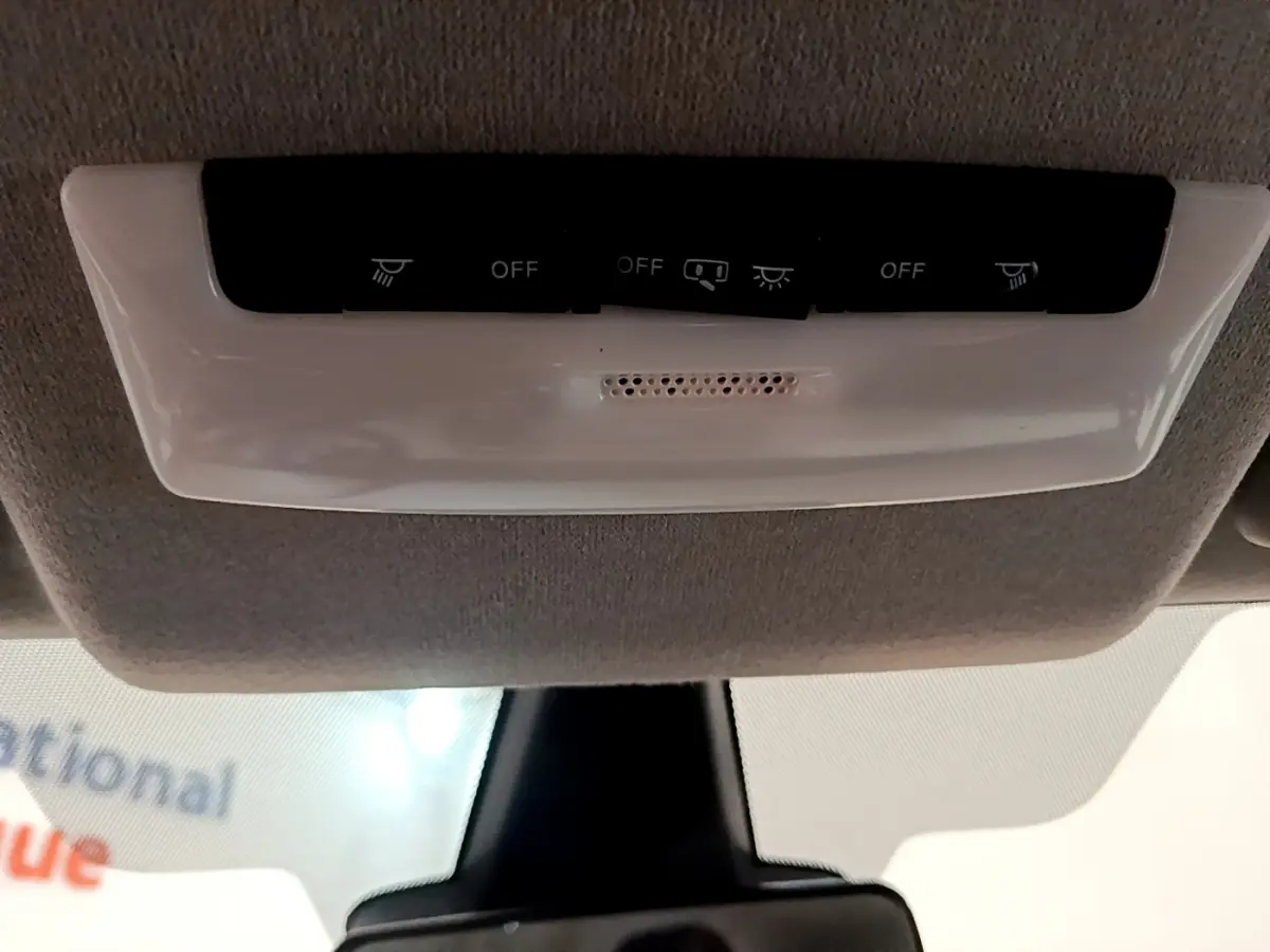 Vue intérieure du plafonnier blanc avec commandes d'éclairage au-dessus du pare-brise d'une Nissan Micra blanche 2022.