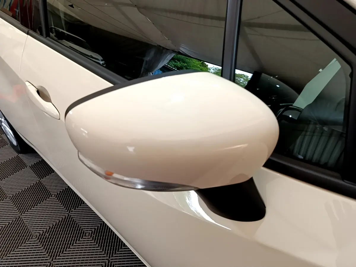 Gros plan sur le rétroviseur côté gauche blanc de la Nissan Micra IG-T 92 Acenta 2022 avec poignée de porte assortie.