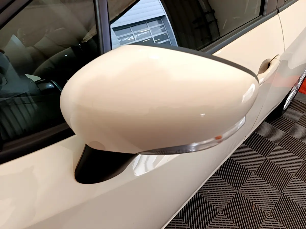 Gros plan sur le rétroviseur côté gauche blanc de la Nissan Micra IG-T 92 Acenta 2022, avec clignotant intégré.