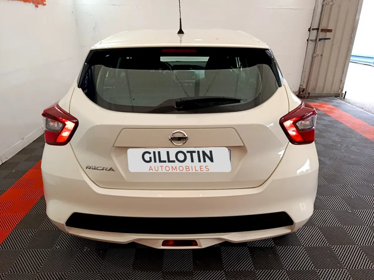 Vue arrière d'une Nissan Micra blanche 2022 garée en intérieur avec feux arrière LED allumés.