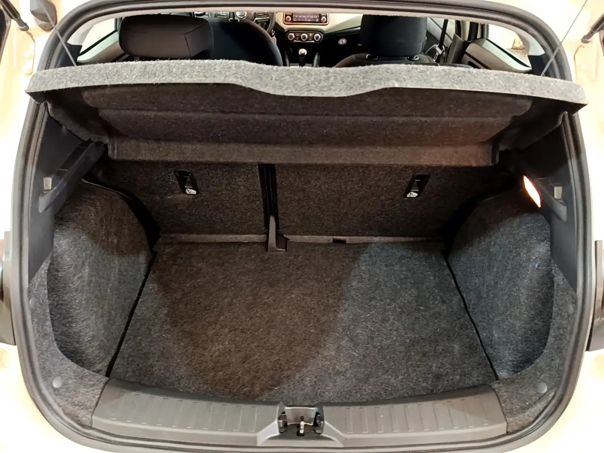 Coffre ouvert d'une Nissan Micra blanche 2022, vue de l'arrière montrant l'espace de chargement et l'intérieur partiel.