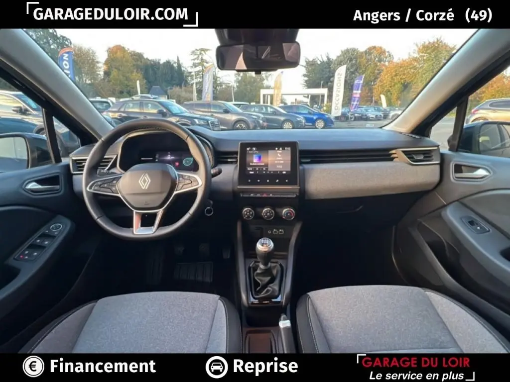 Vue intérieure avant de la Renault Clio noire 2025 montrant le volant cuir multifonctions et l’écran tactile central.