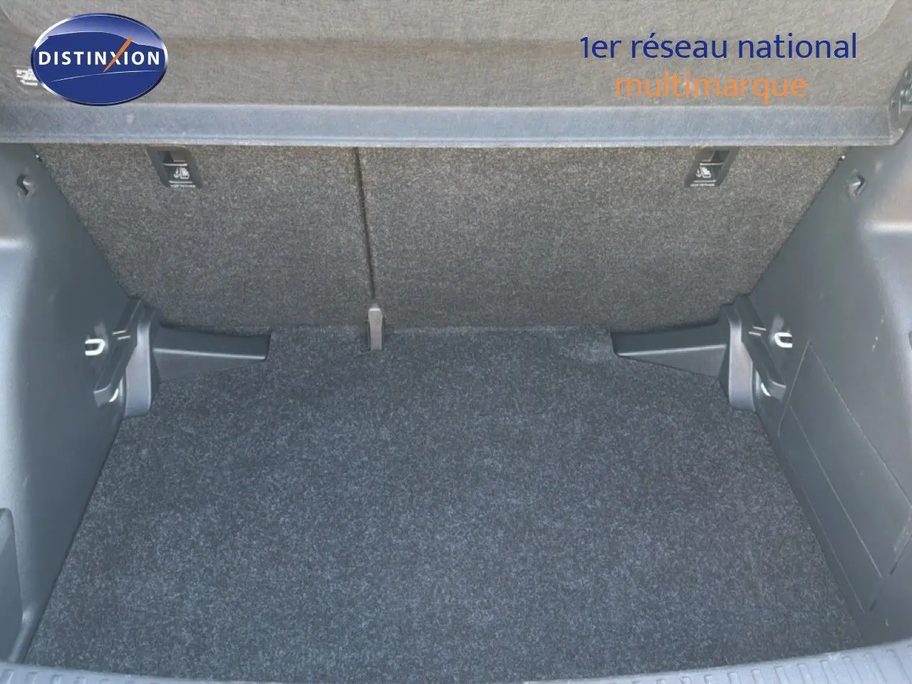 Coffre ouvert d’une Skoda Fabia gris graphite métal, vue arrière montrant l’espace de chargement vide et le cache-bagages relevé.