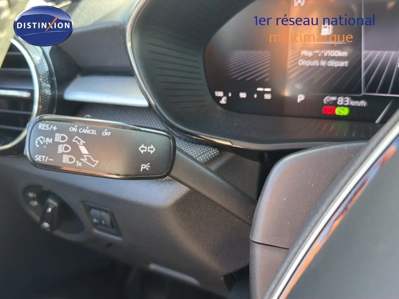 Gros plan sur la commande de régulateur de vitesse à gauche du volant dans l’habitacle d’une Skoda Fabia gris graphite.